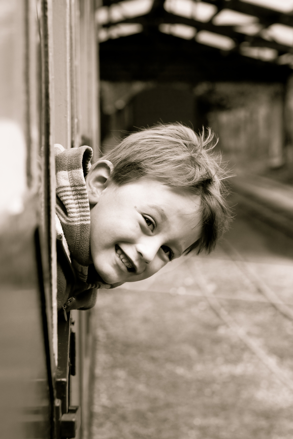 Little boy leaning out of a train window